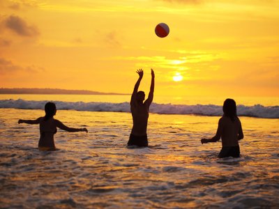 people playing volleyball in the sea