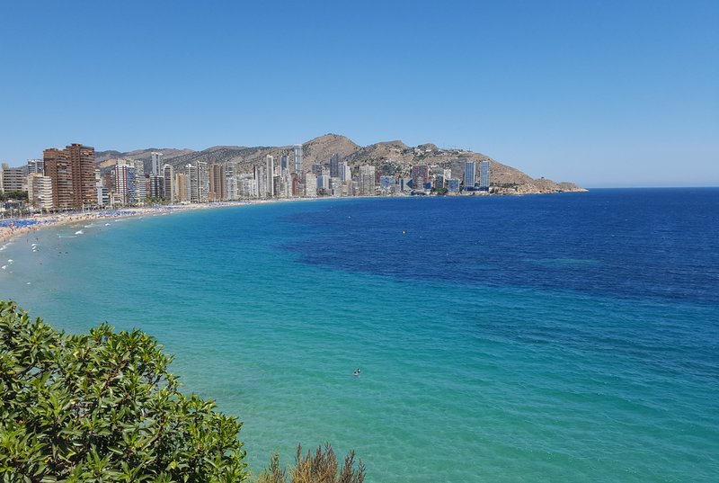 Playa de Benidorm con mar y arena bajo el cielo despejado
