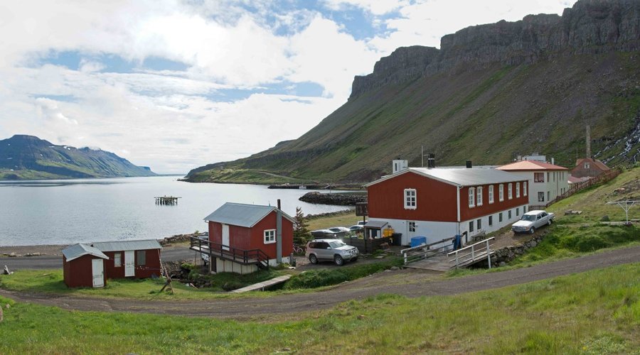 The hotel with the cabin to its left, the fjord and the tabletop mountains
