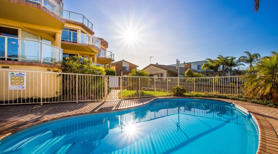 Sunrise over Baywatch + Pool area with deck chairs. (Not in photo).