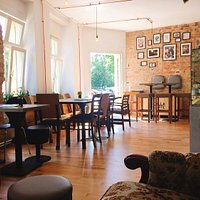 Café mit gemütlichen Sitzplätzen, Couch und Mooswand