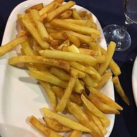 Frango assado bom com batata frita e salada com tomate, a entrada sopa de legumes. Bom vinho da