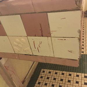 Blood spatter and handprint on bathroom sink cabinet