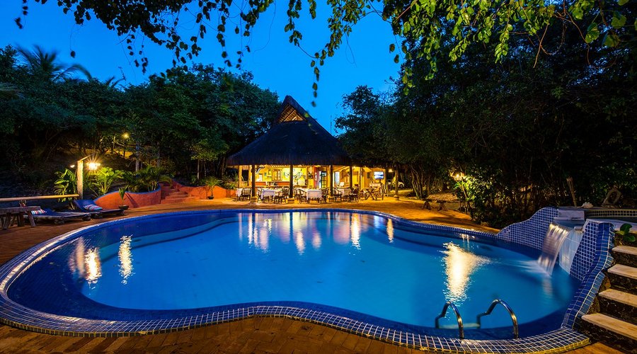 Ambiente acolhedor da piscina e restaurante ao entardecer