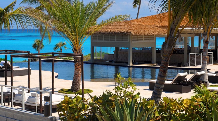 Beachfront infinity pool with swim up bar and poolside service.