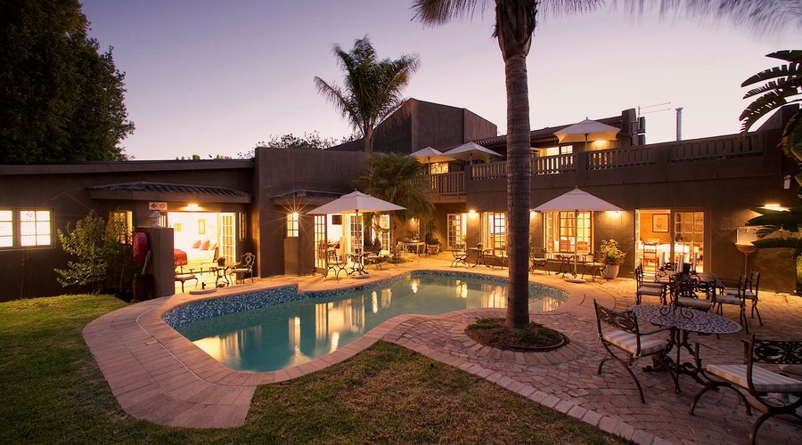 Leisure area with lawn, pool loungers and pool with seating area