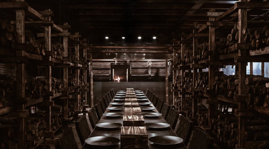 6,300 logs, 5 communal tables, 1 open kitchen and a wooden structure containing the space give s