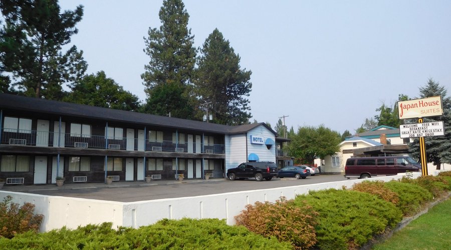 Cars are parked in front of exterior stairwell that blocks view from some rooms.
