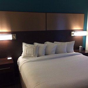 King-size bed; note bedside tables that have plenty of room and wall-mounted lights