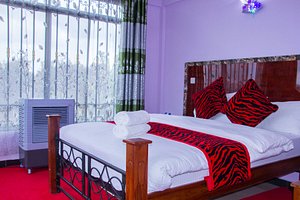 Africana Grand Hotel in Arusha, image may contain: Furniture, Bedroom, Bed, Indoors