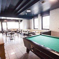 Interno del locale con molto posto, bancone, divanetti e bigliardo