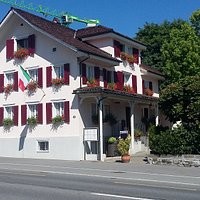 Ein Restaurant / Hotel mit einer Gartenwirtschaft in der alte Kastanienbäume Schatten spenden