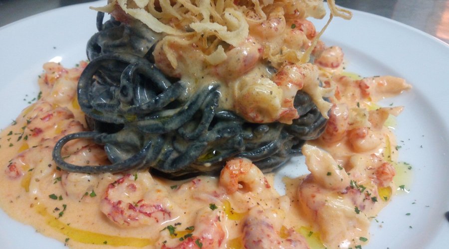 Tagliolini freschi al nero di seppia con aragostelle di fiume e finocchio croccante...