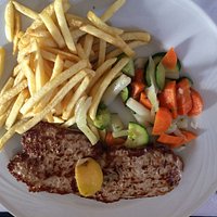La bistecca ai ferri con patatine e verdure.
