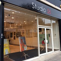 Contemporary paintings behind bland shop front.