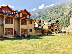 Hotel Akbar Sonamarg in Srinagar, image may contain: Hotel, Resort, Building, Chair