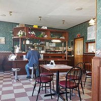 Customer reading the newspaper at the counter while waiting for take out.