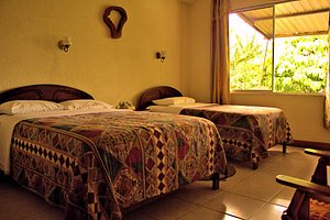 Hotel Los Yutzos in Tena, image may contain: Bed, Furniture, Hotel, Bedroom