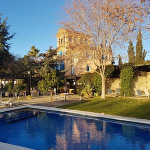 Primer plano de la piscina y la casa modernista (hotel)