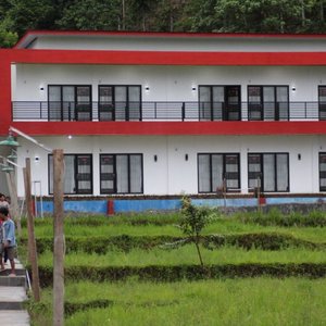 Bangunan Hotel tampak depan. Ada Lapangan Badminton, Futsal, Sawah, Kolam Ikan dan Bangunan Cott