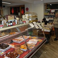 Clienti alla cassa e seduti intenti a degustare una pizza.