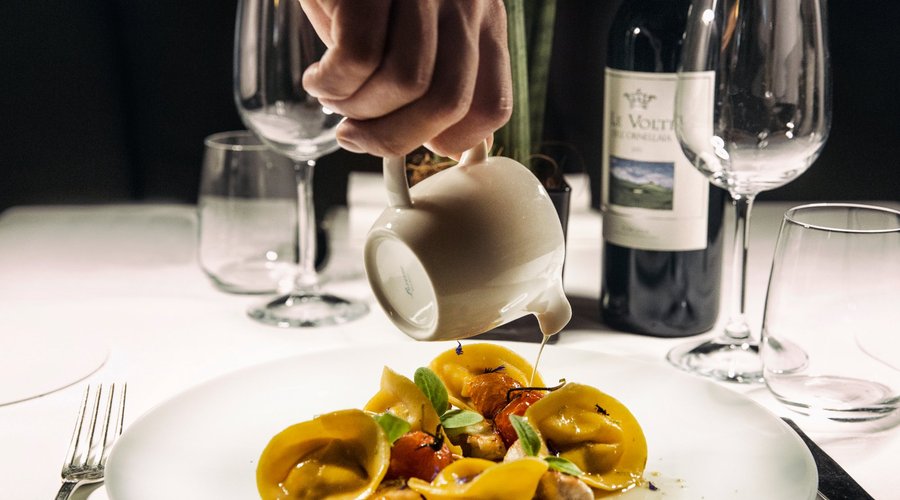 Tortelli con gallinella di mare e datterini con acqua di vongole e basilico trasparente