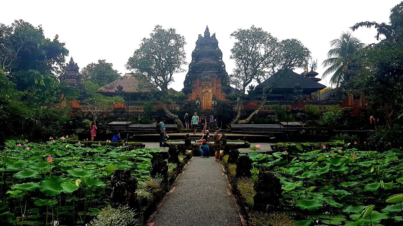 Intricate red brick temple gates with traditional Balinese stone sculptures