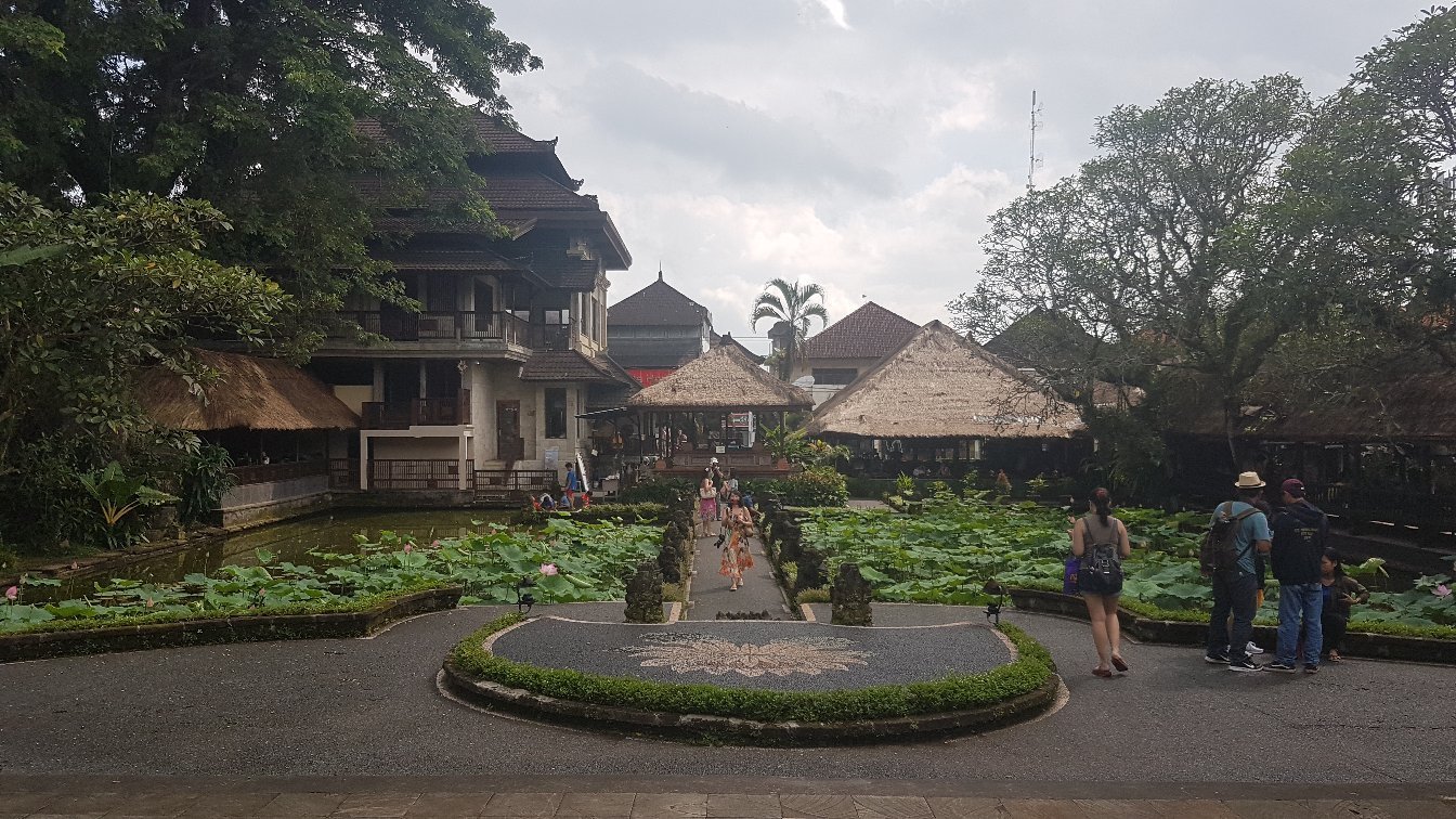 Dancers performing traditional Legong dance in temple courtyard