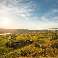 An aerial photo taken of the fort and Oldman River valley from above the coulees during sunset