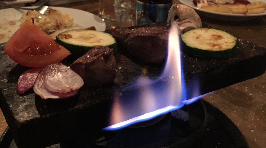 Renfilé och grönsaker steks på varm täljsten