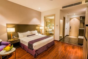Amara Gateway Hotel in Moradabad, image may contain: Interior Design, Furniture, Bedroom, Wood