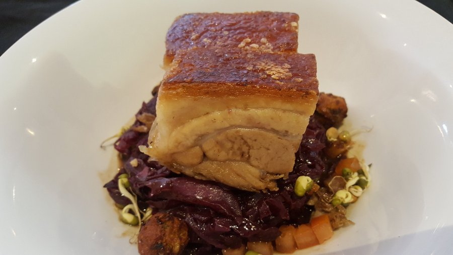 Slow braised pork belly with red cabbage, caramelized apple and sprouts