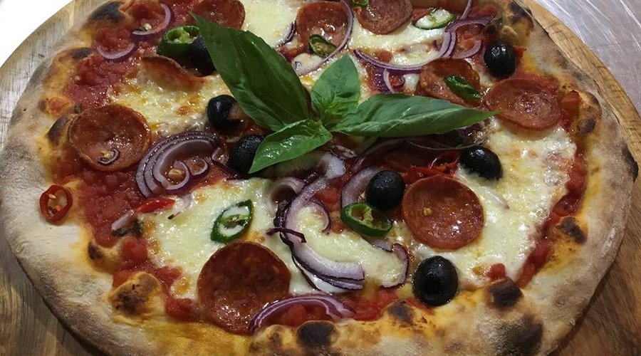 Pepperoni pizza with added toppings, chilli, red onion and black olives