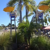 Pensive lifeguards art installation at entry to village