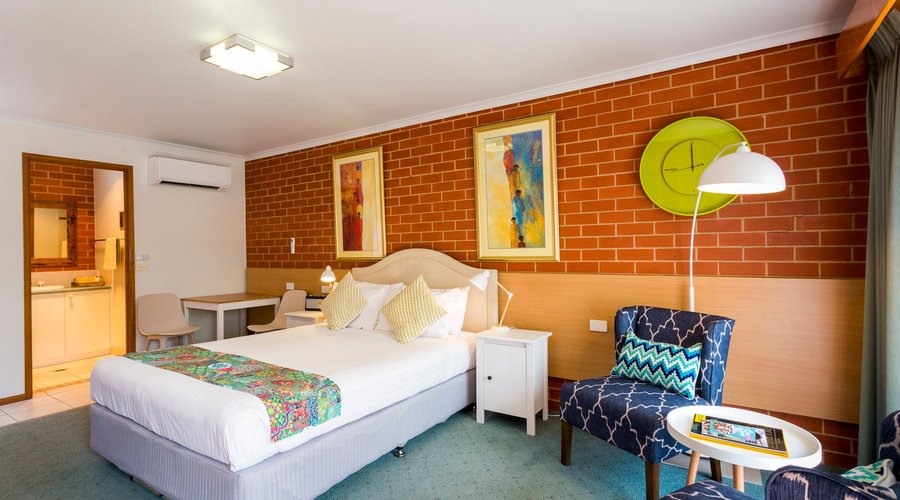 Queen deluxe room #8, small dining set in the corner and reading chairs in the foreground. 