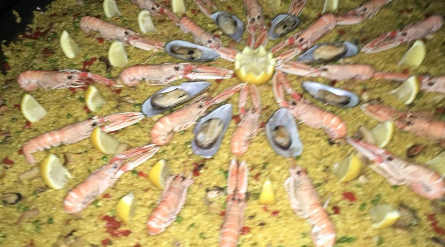 Gesellschaft mit Show Paella Cooking. Lecker
