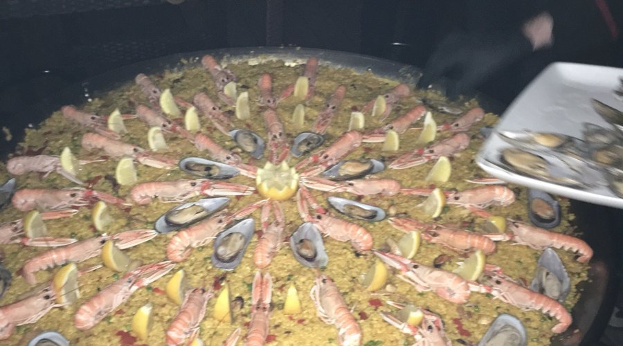 Gesellschaft mit Show Paella Cooking. Lecker