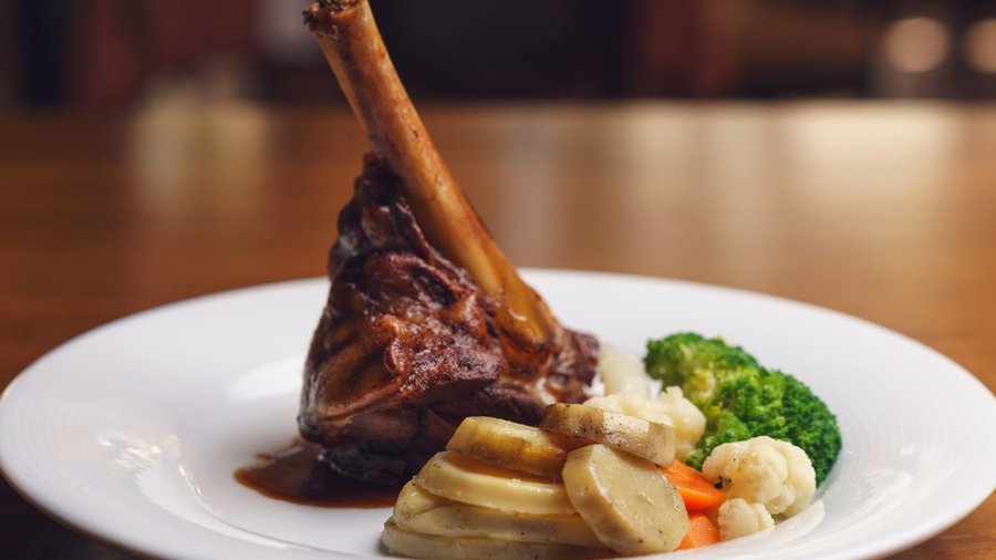 Lamb knuckle with roasted potatoes and steamed vegetables
