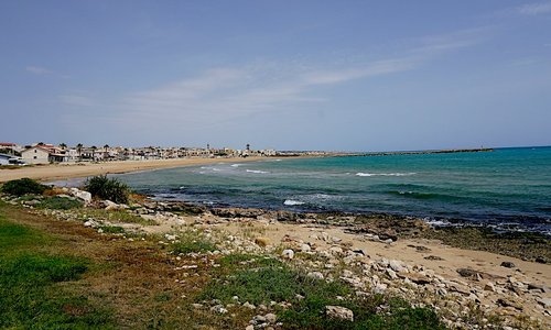 Rocky beach directly in front of hotel and grassy lounging area