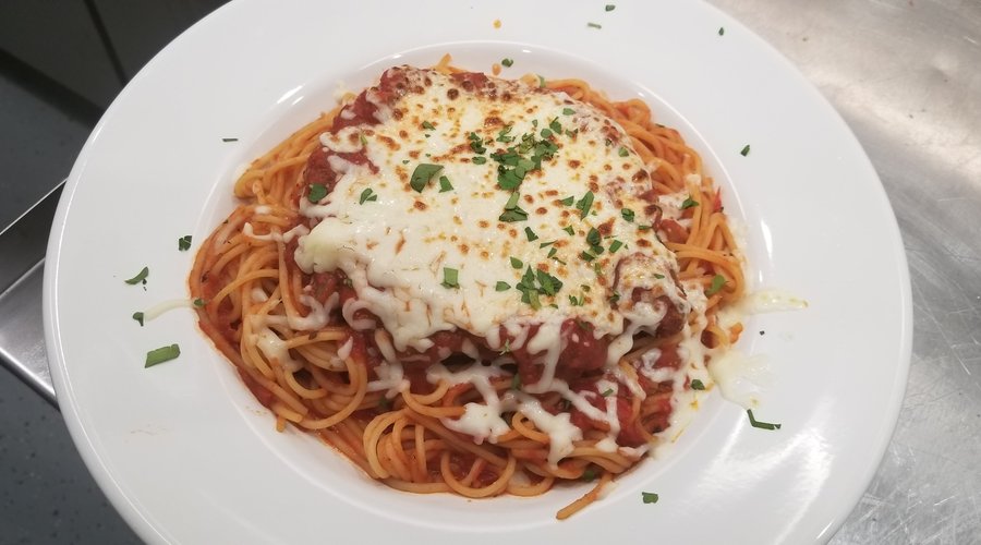 Chicken Parmigiana--Hand breaded & fried chicken breast, topped with mozzarella on spahetti.