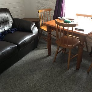 Tiny living area, showing 2 seater couch and small table and chairs