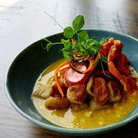 Gnocchi with Jalapeno Corn Broth garnished with pickled vegetables and crispy prosciutto