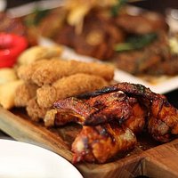 Grille mixed tapas. Roasted chicken wings, fried fish fingers, samosa and tangy sauce to dip.