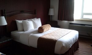 Invermere Inn & Suites in Invermere, image may contain: Bed, Furniture, Lamp, Bedroom