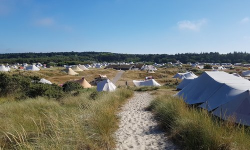 Camping gezien vanaf de duinen bij zee.