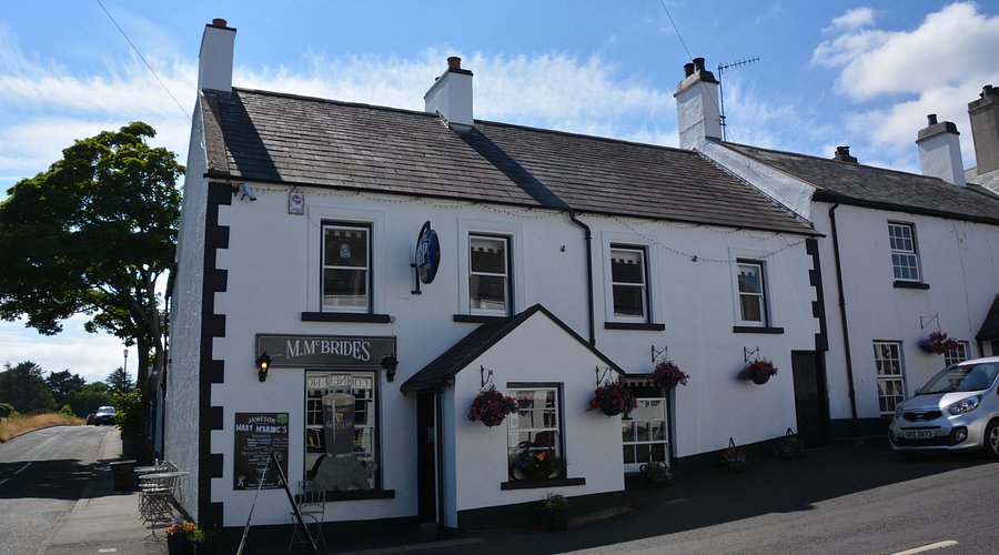 The quaint exterior of Mary McBride's pub in Cushendun, known as one of Ireland's smallest public houses.