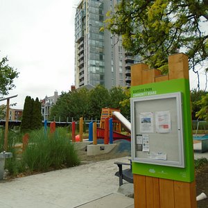 Playground area and noticeboard. Railway in background