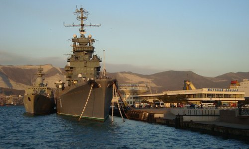 Великан красавец-крейсер рядом с пришвартовавшимся судном 