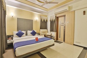 Capital O 978 Marshall The Hotel in Ahmedabad, image may contain: Corner, Interior Design, Bed, Rug