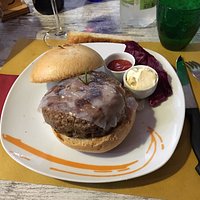 Hamburger farcito di formaggio e cipolle e rivestito da lardo